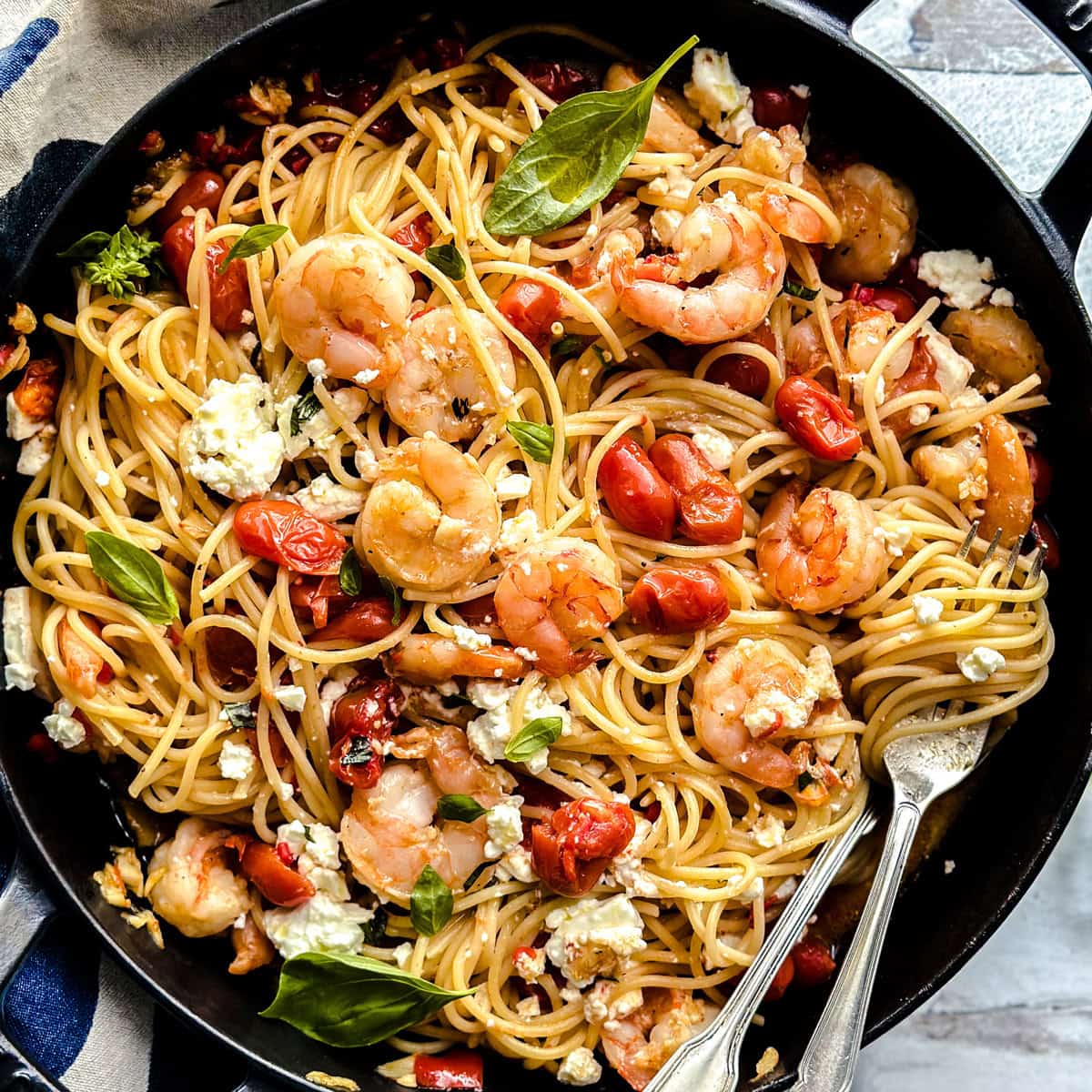 Spicy shrimp spaghetti Greek garidomakaronada, with cherry tomatoes, feta, and basil served in a skillet