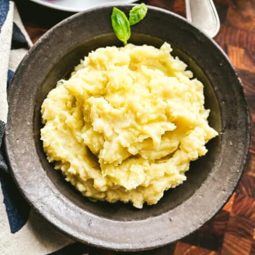 A bowl with skordalia, the Greek potato garlic dip on a wooden table.