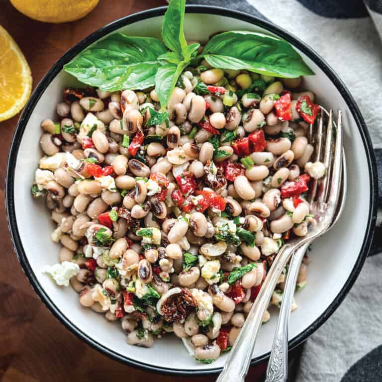 A black eyed pea salad and fresh basil in a plate.