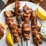 Greek pork souvlaki Kalamaki skewers with bread and lemon wedges