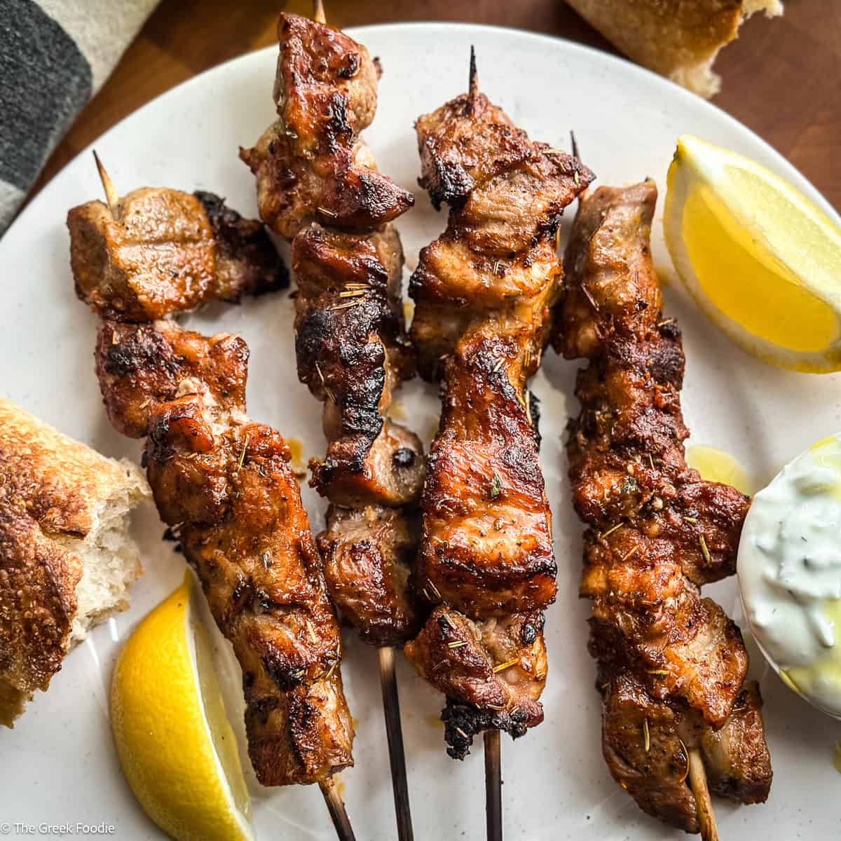 Greek pork souvlaki Kalamaki skewers with bread and lemon wedges