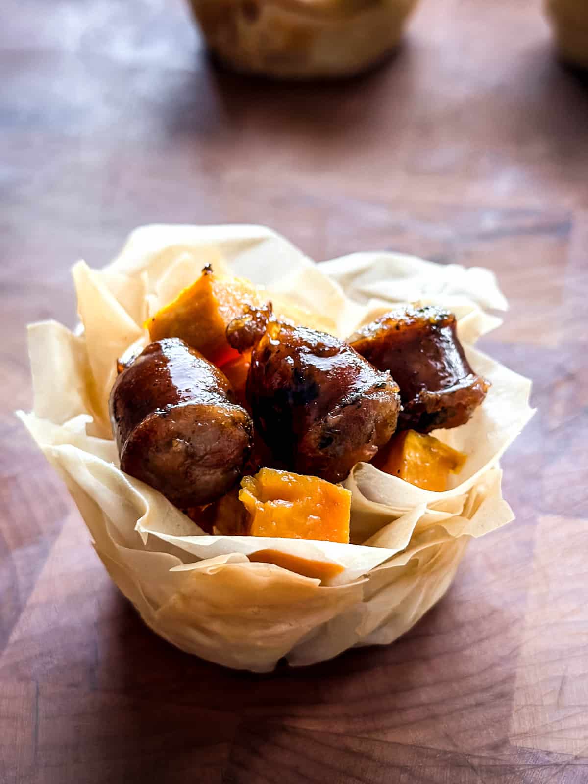 A phyllo cup appetizer with sweet potato and sausage.