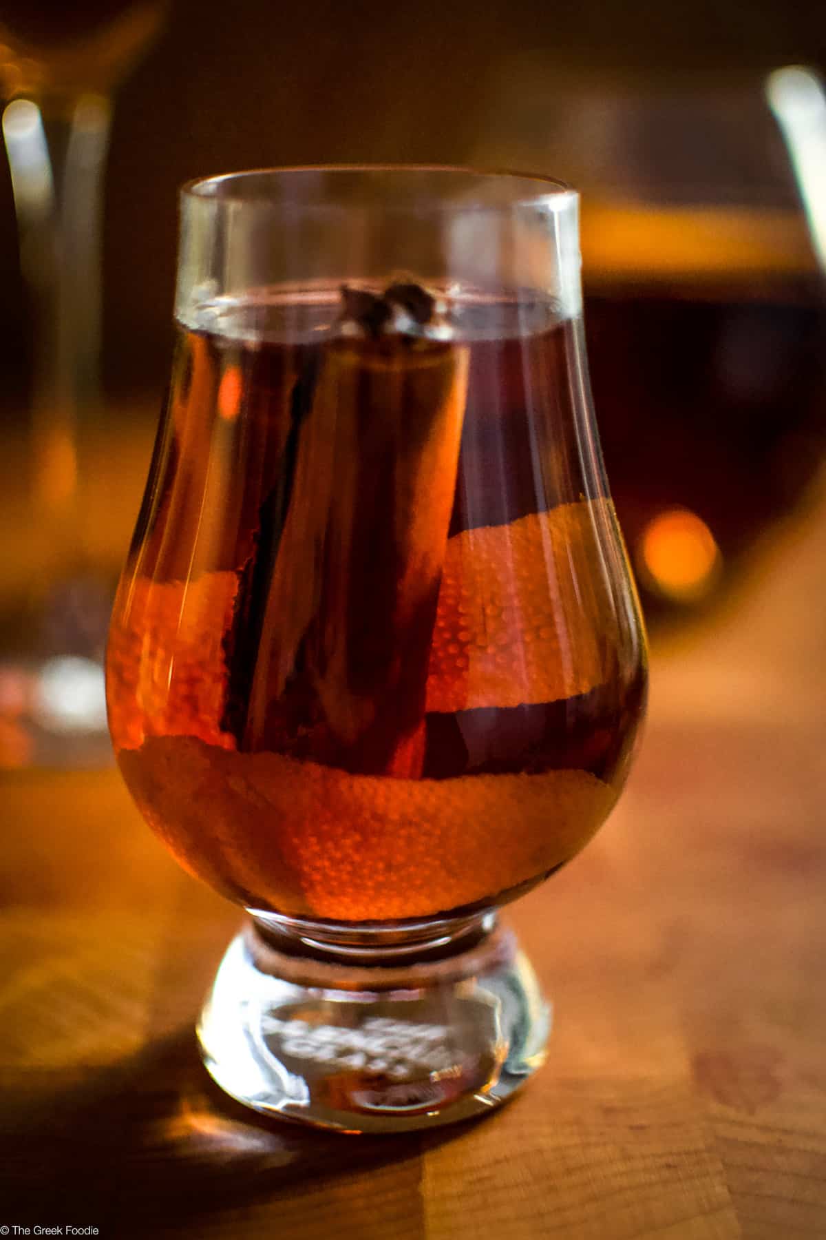 A small glass with rakomelo, raki drink with honey in a wood environment.