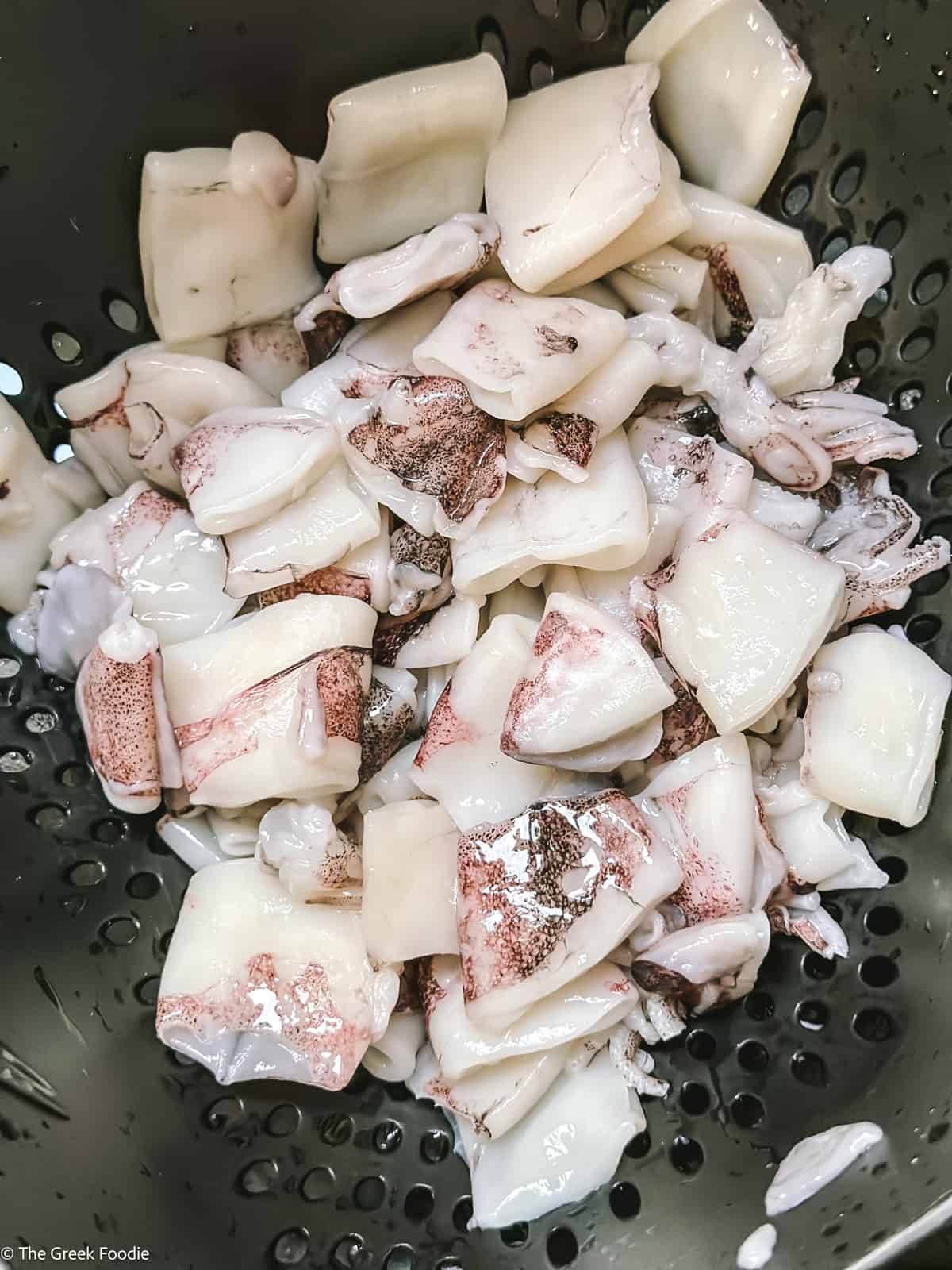 Cleaned squid in a collander.