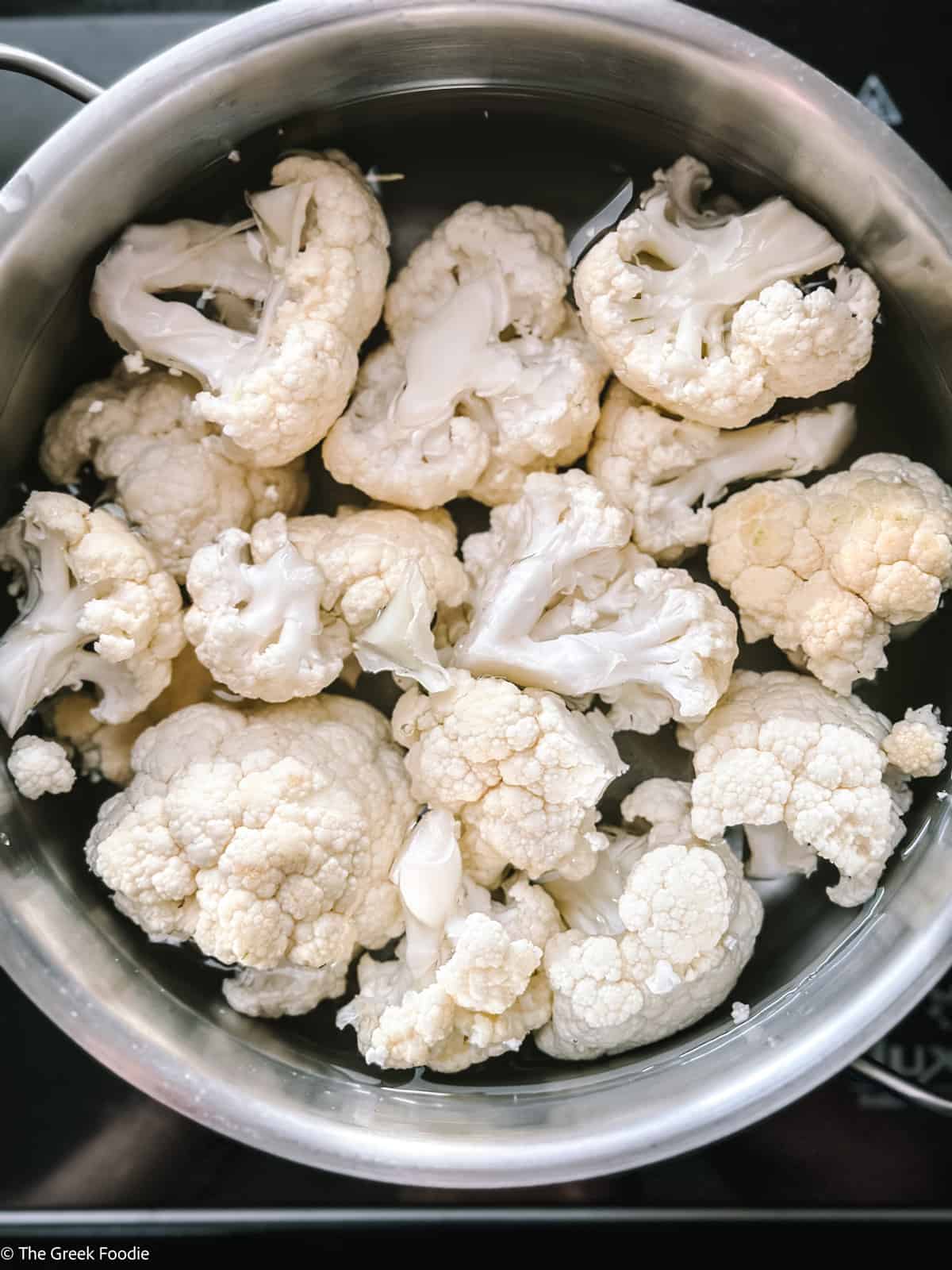 Cauliflower florrets cooking in water.