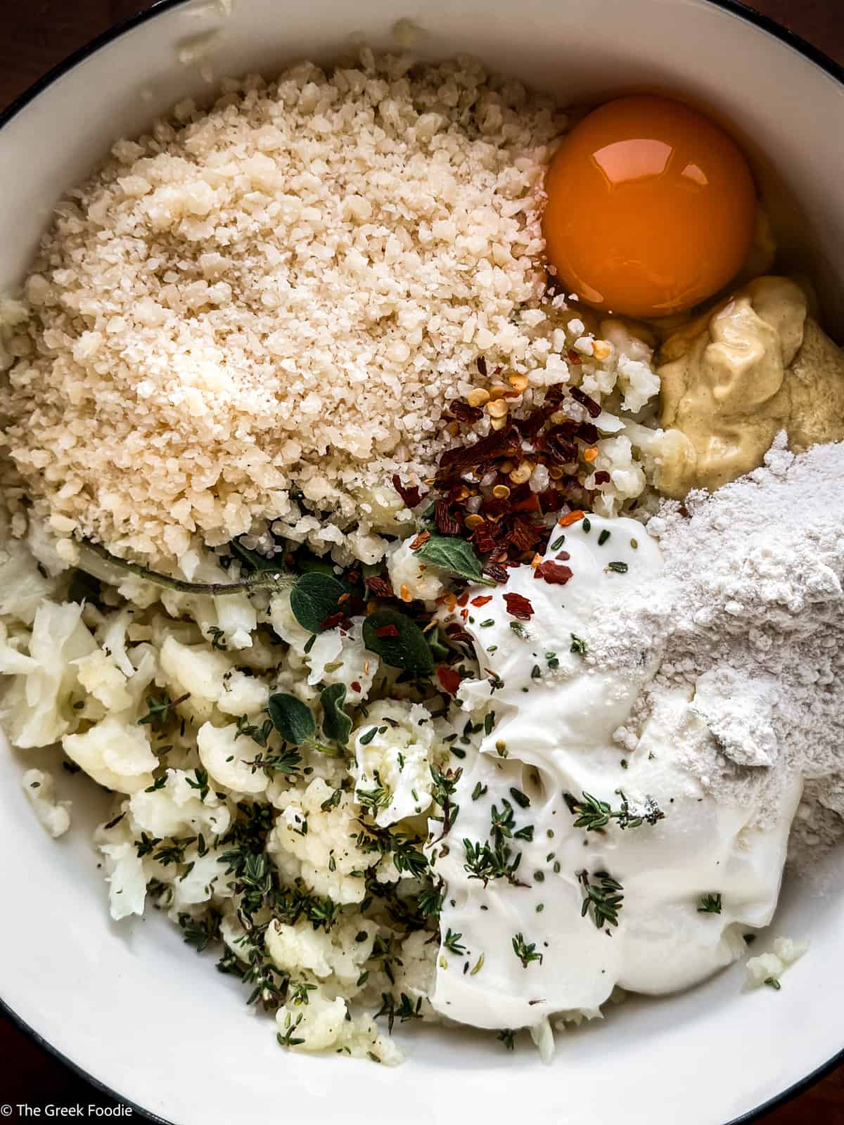 Ingredients to make cauliflower fritters in a bowl.