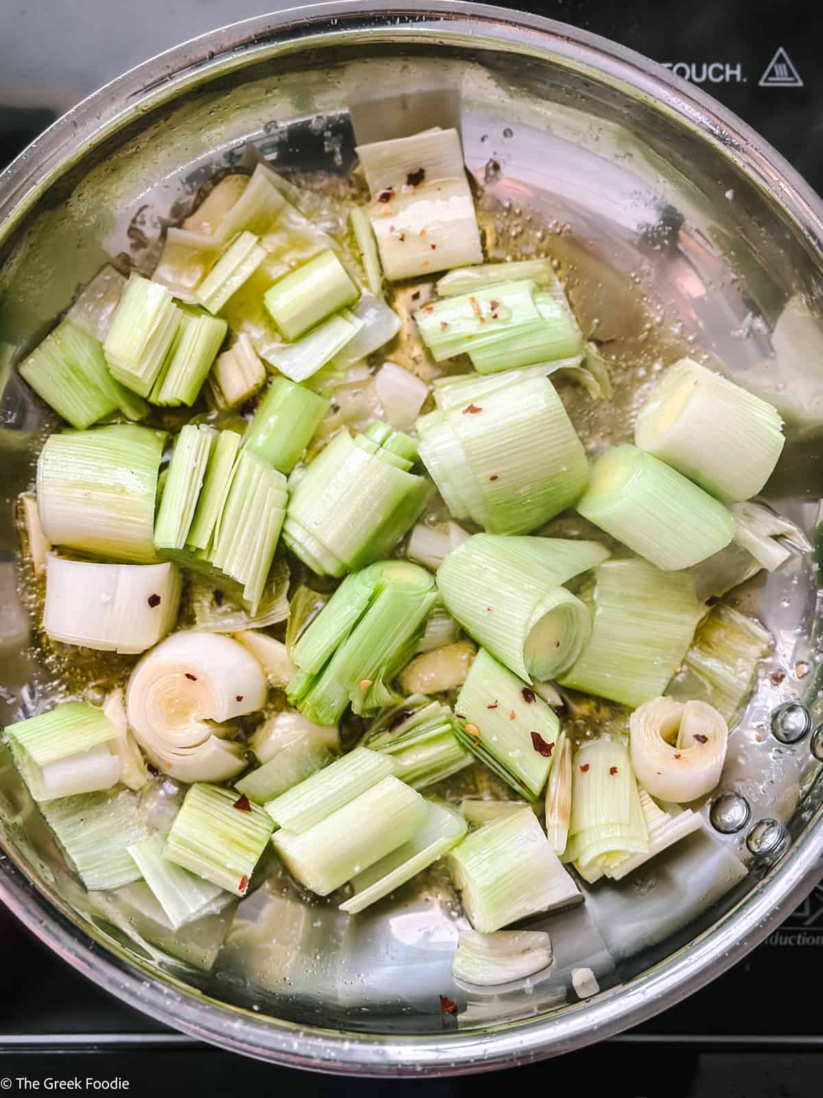 Roughly chopped leeks and garlic in a skillet with olive oil.