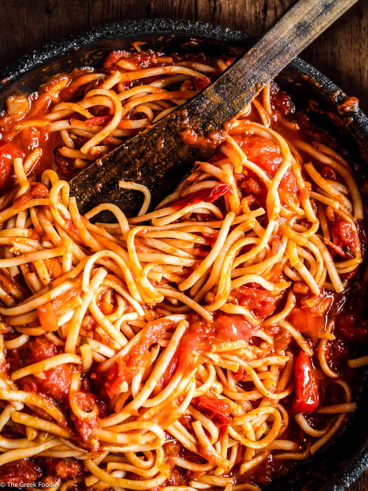 A bowl with tomato garlic pasta.