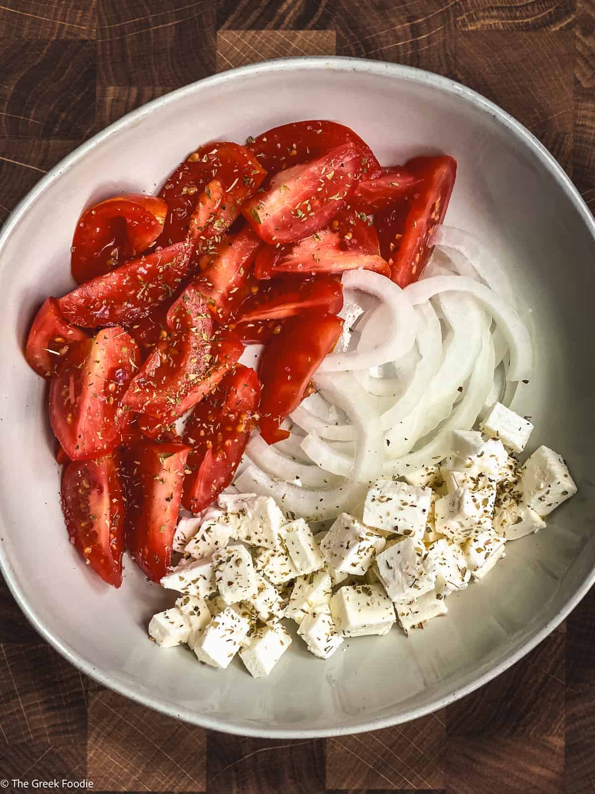 Tomato wedges, onion slices and feta cubes in a plate.