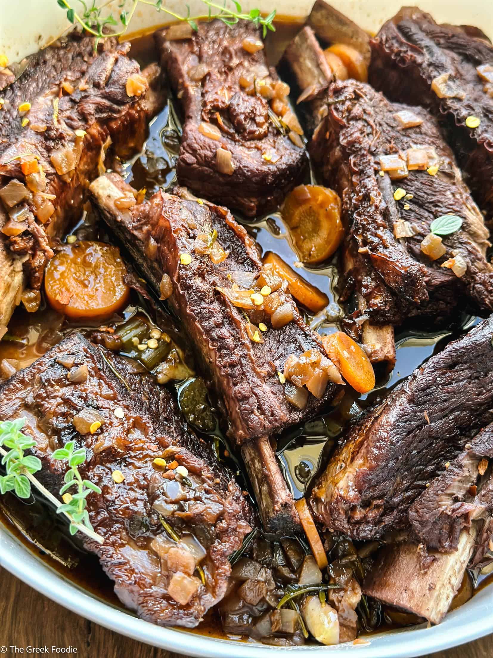 Close-up of fall-off-the-bone braised beef short ribs in glossy red wine sauce
