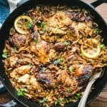 Greek lemon chicken orzo in a skillet with lemon slices