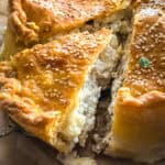 A Cretan meat pie Kreatotourta, with a piece taken out.