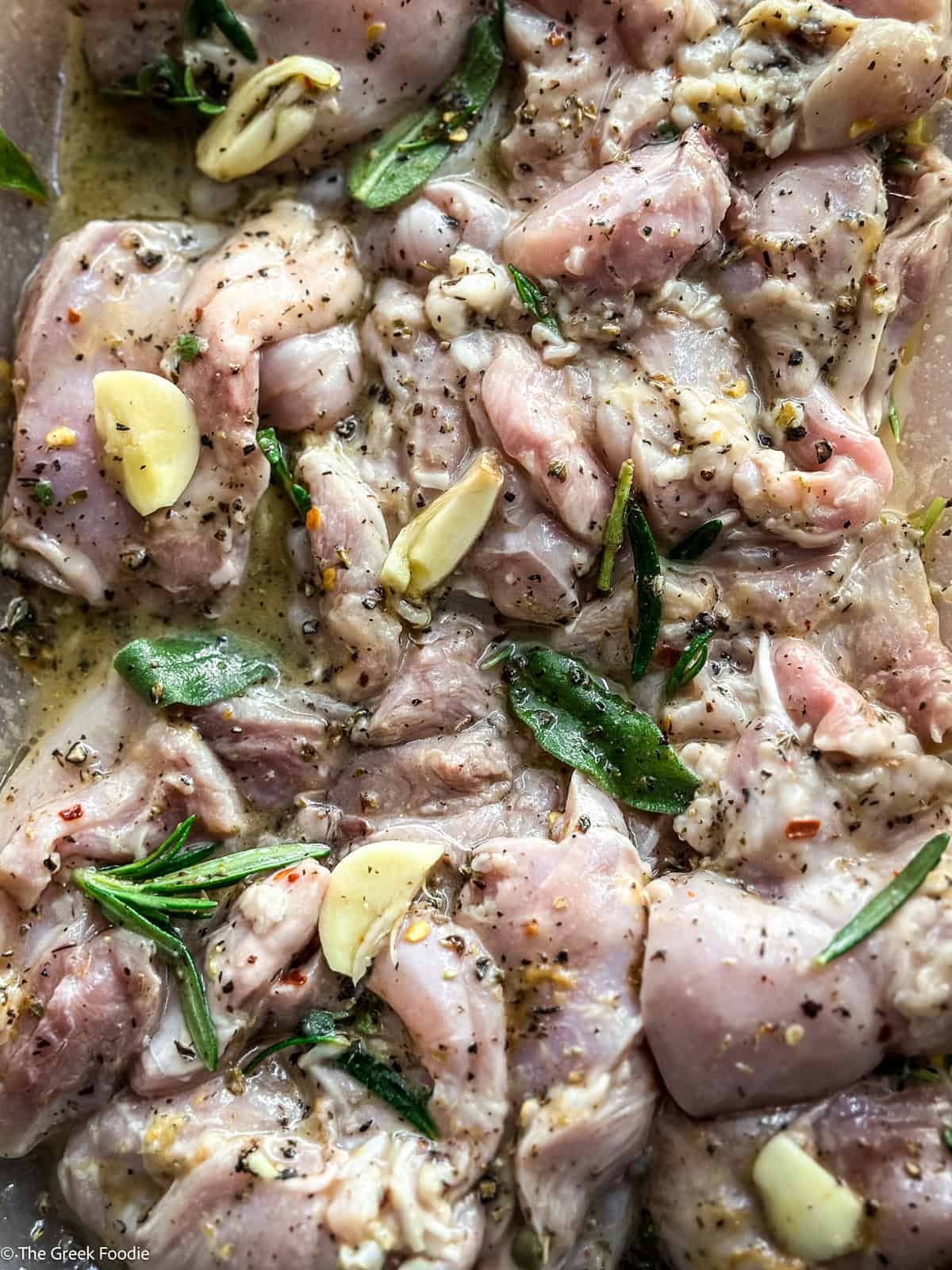 Chicken marinating with fresh herbs and spices.
