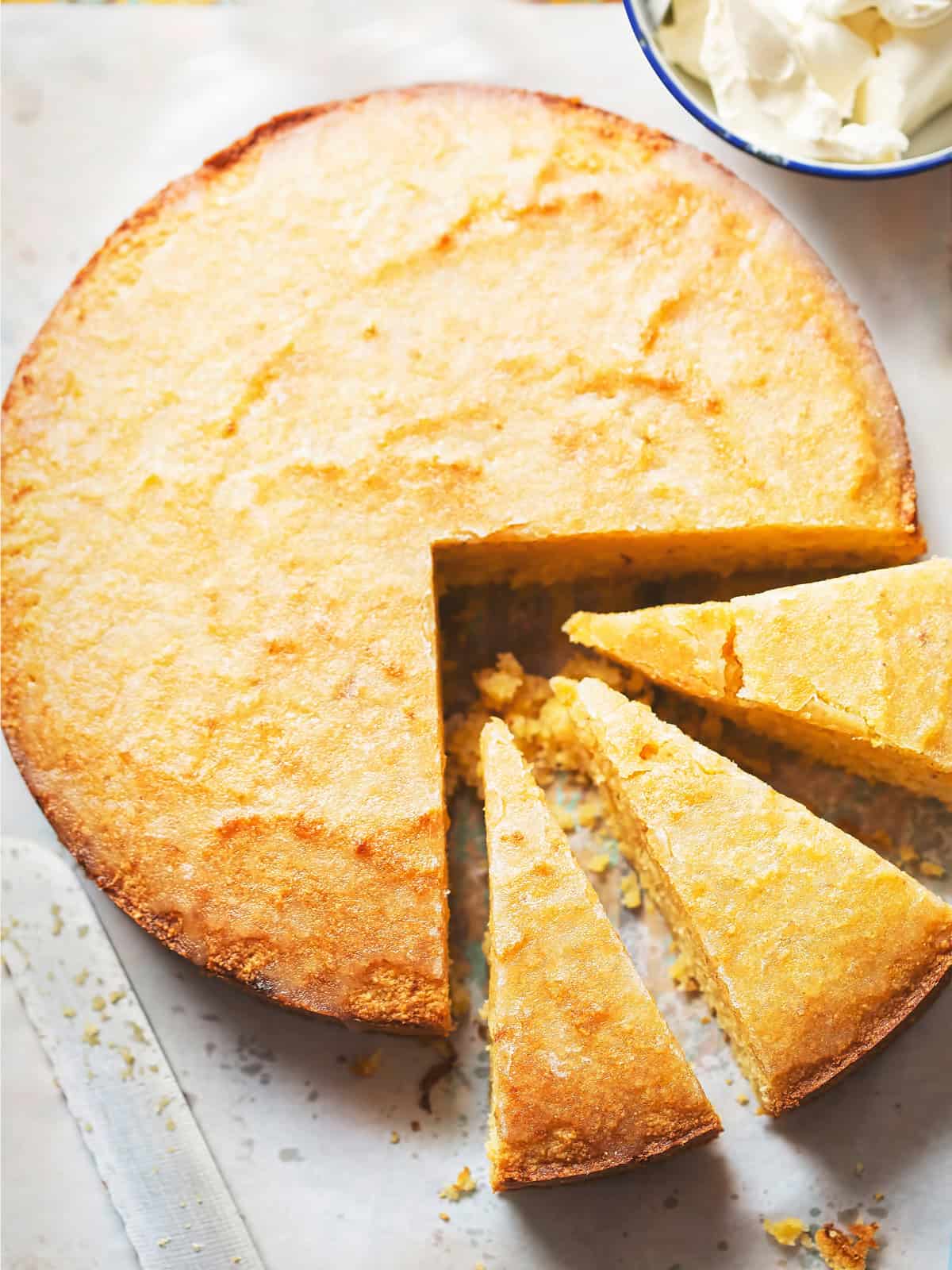 An olive oil cake sliced on a parchment paper.