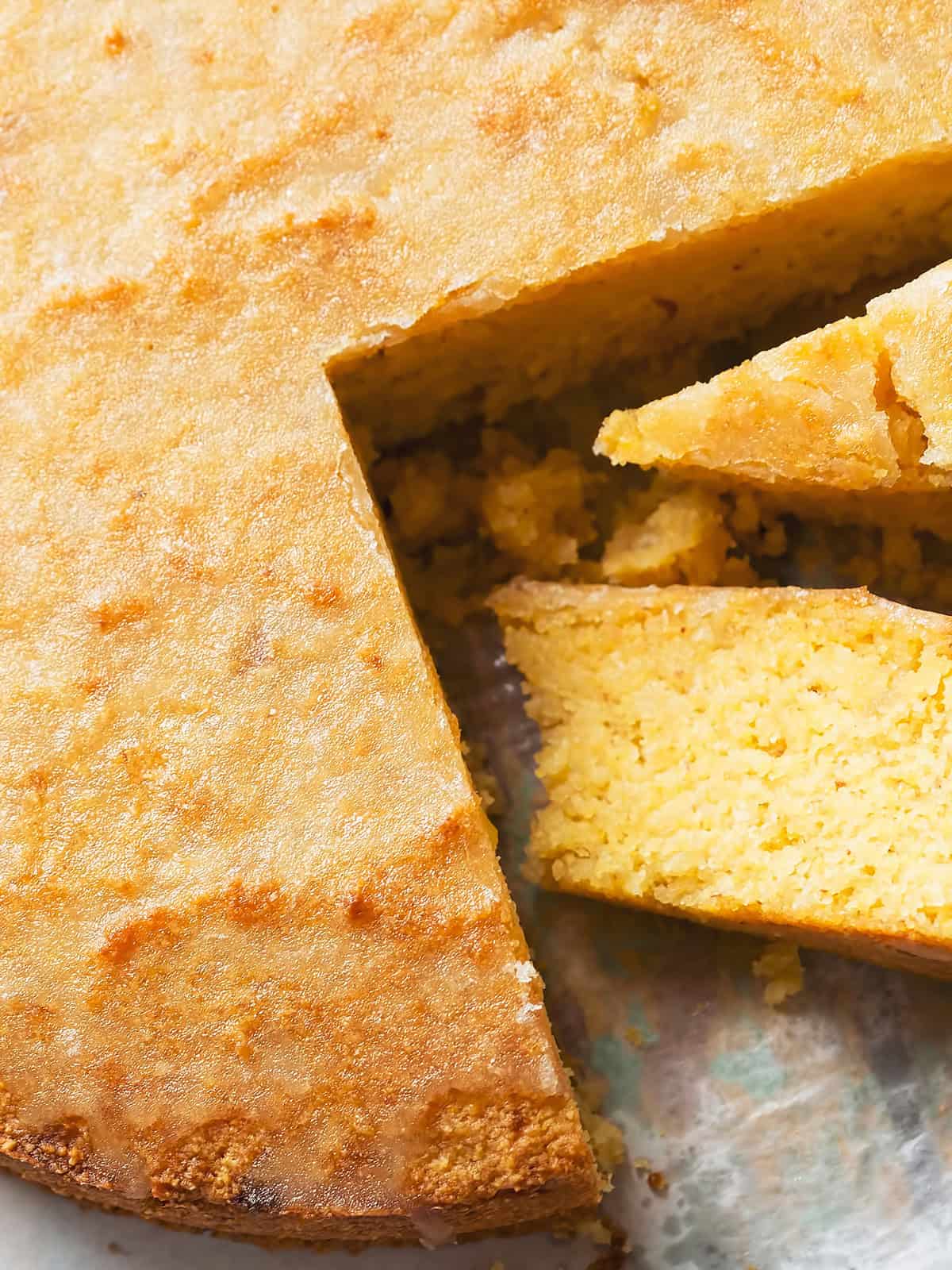 An olive oil cake sliced on a parchment paper.