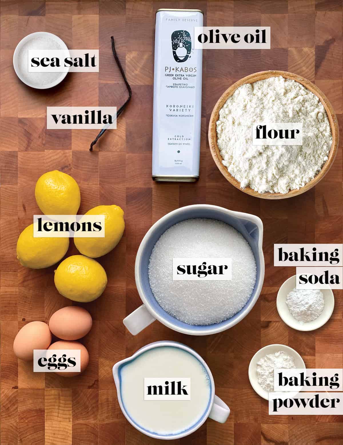 Flour, lemons, olive oil, eggs, baking soda and powder, vanilla pod, and milk on a wooden surface for a lemon olive oil cake recipe.