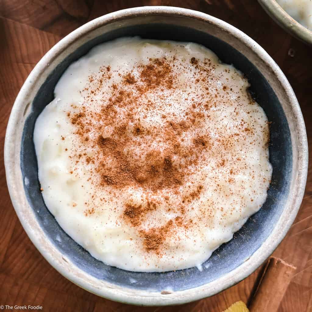 A bowl with rizogalo-Greek rice pudding on a table.