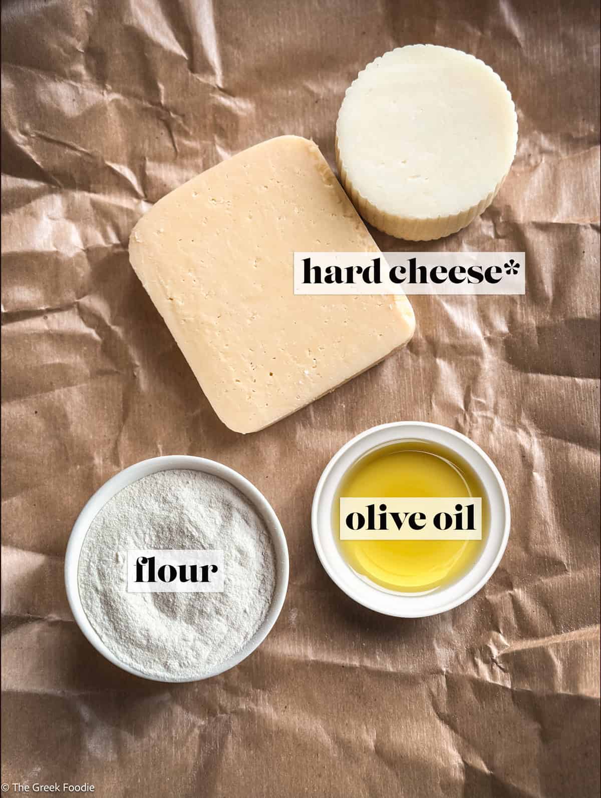 Two pieces of hard cheese, flour and olive oil on parchment paper.