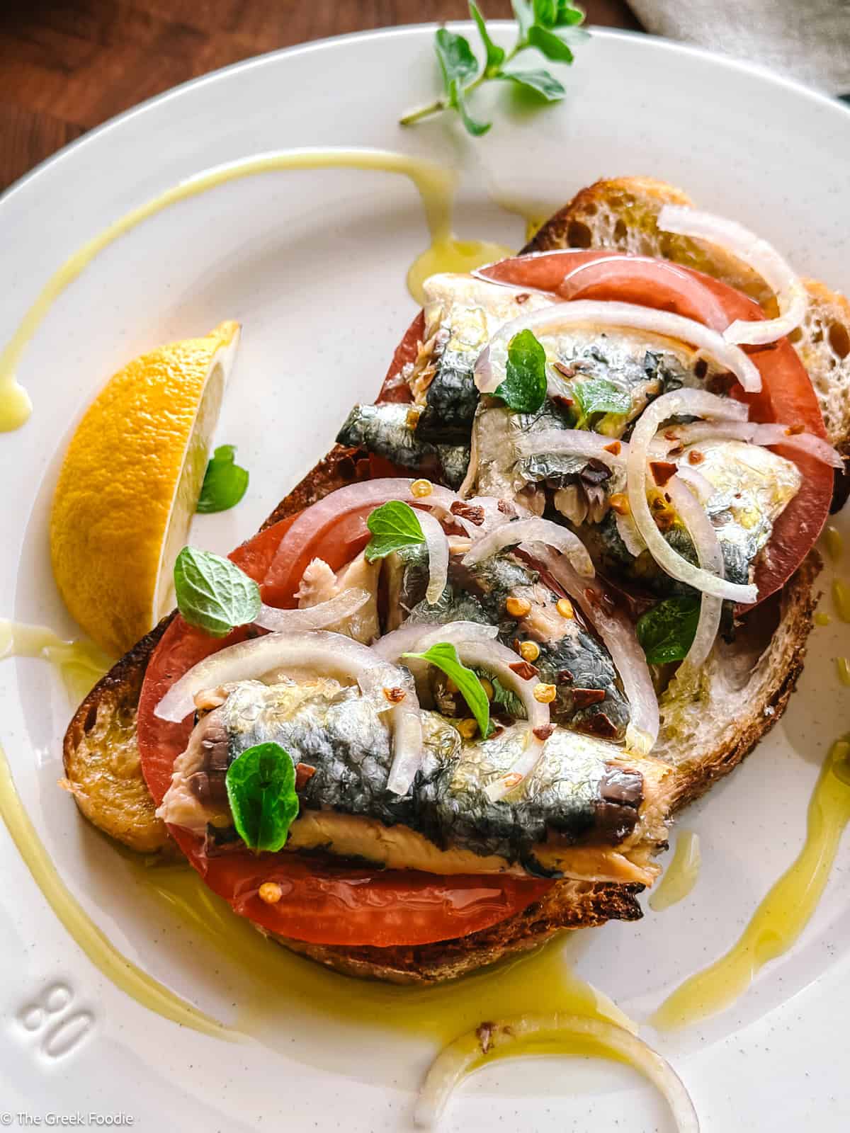 Sardines on toasted sourdough bread and lemon wedges.