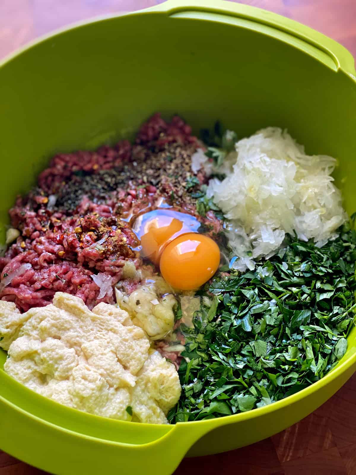 Meatball ingredients in a green bowl.
