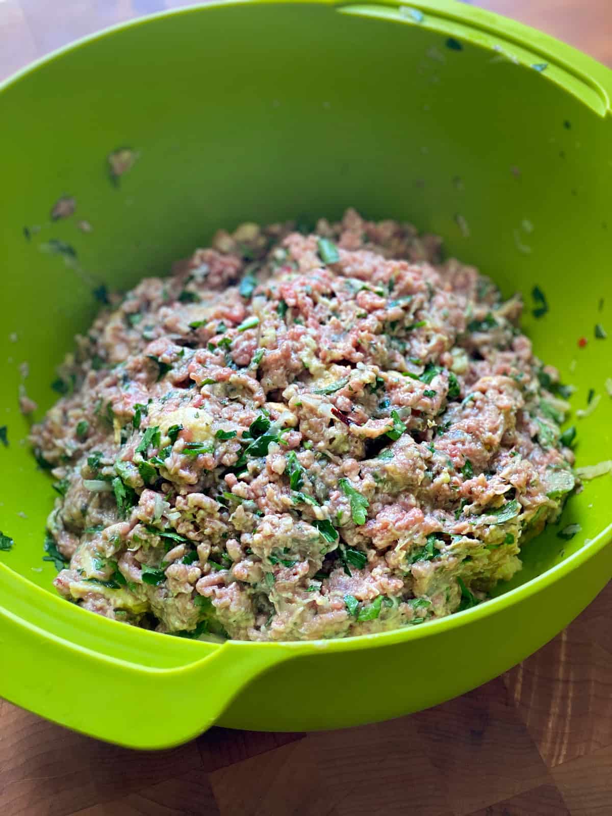 Meatball ingredients in a green bowl.