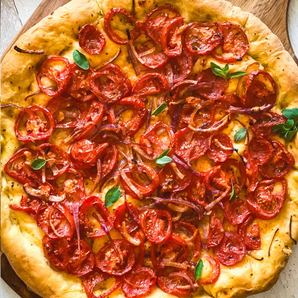 A Ladenia olive oil pie, Greek pizza on a wooden board.