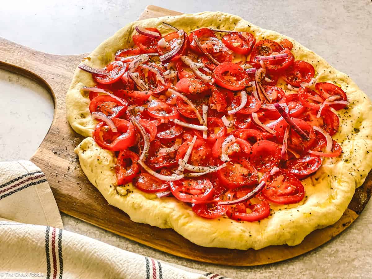A Ladenia olive oil pie, Greek pizza on a wooden board.