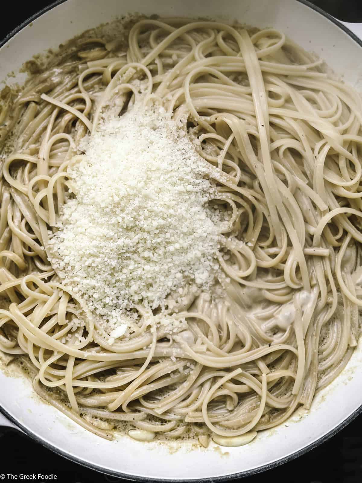 Spaghetti in white sauce with grated cheese on top.