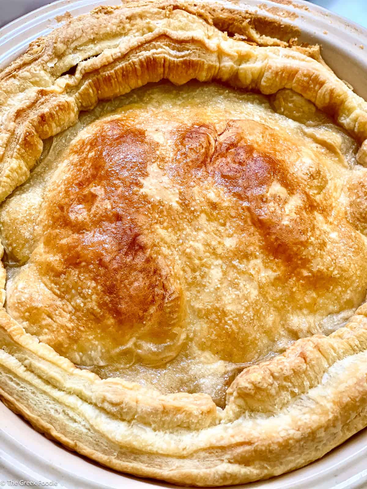 An apple pie in a round tart pan.