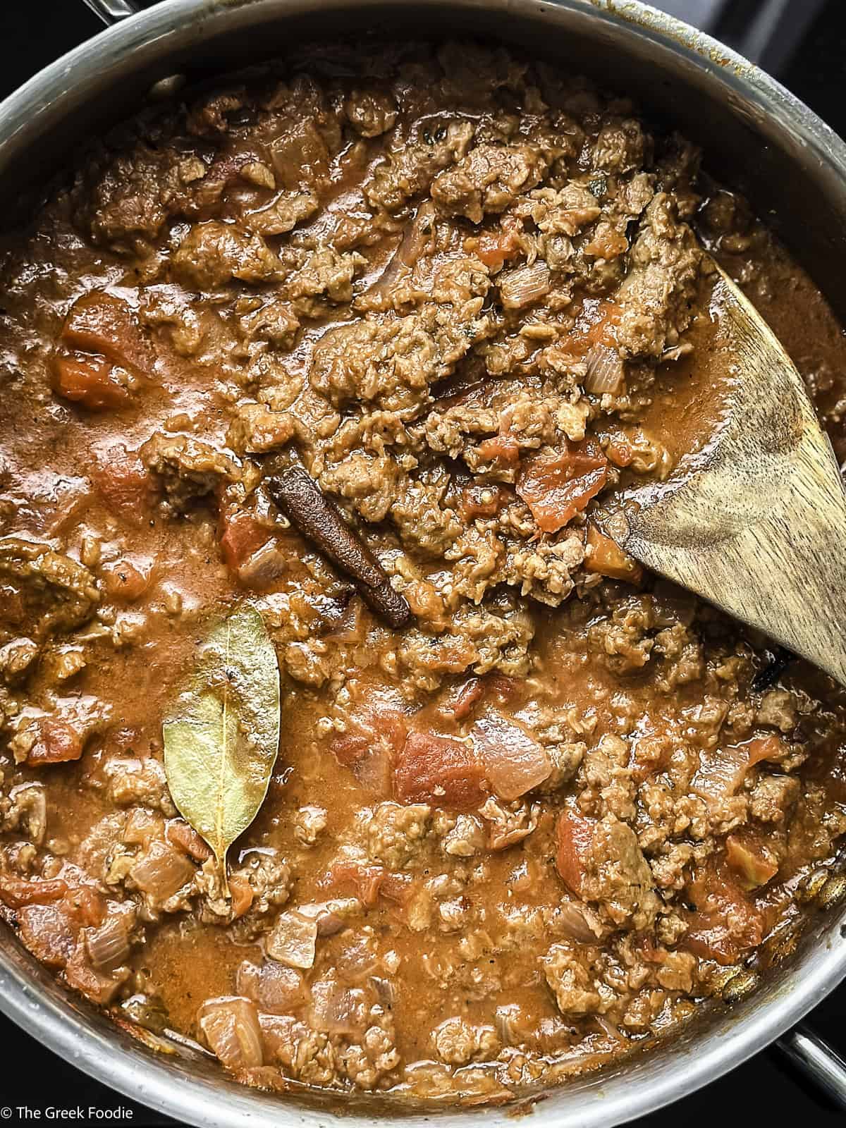 Plant based meat sauce in a skillet with a wooden spoon.