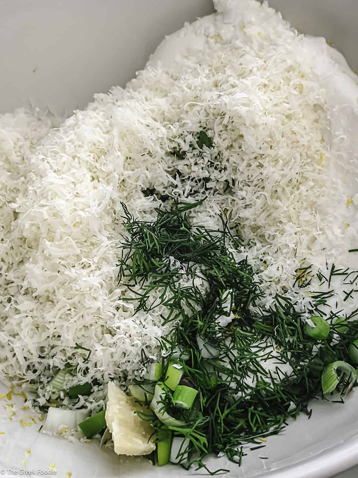 Cheese and herbs in a bowl.