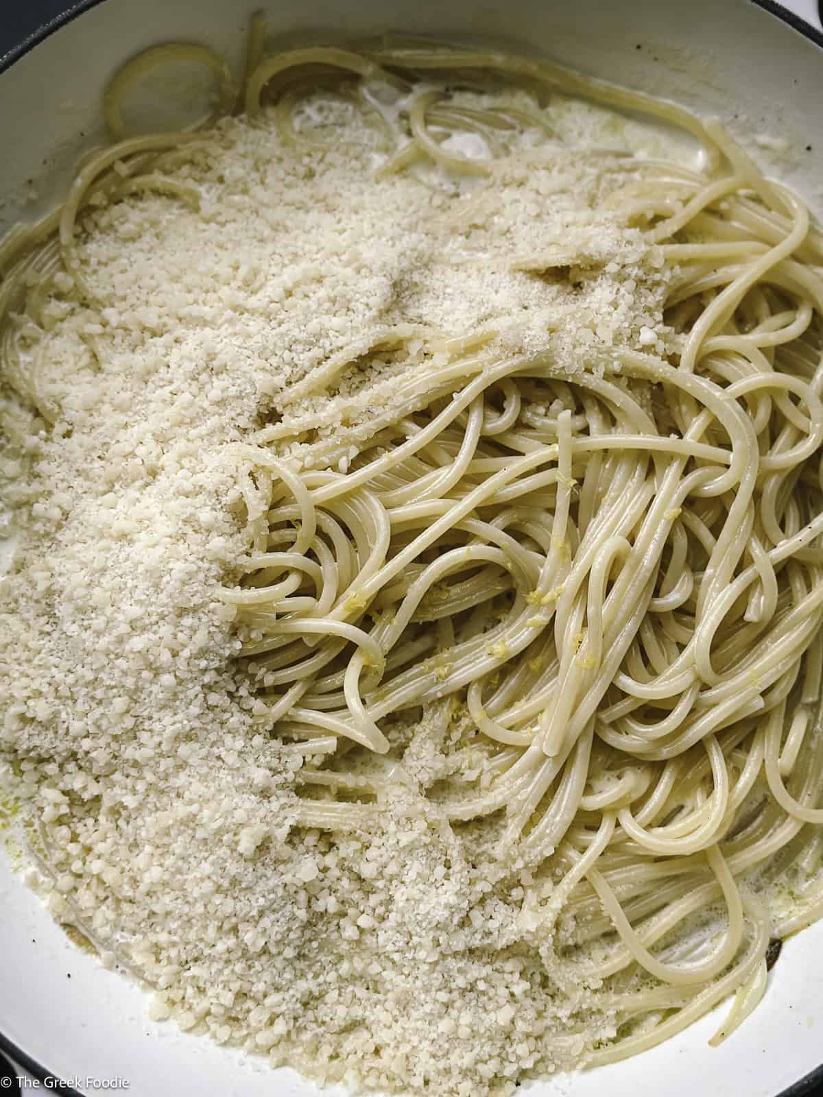 Spaghetti, grated cheese, lemon zest and pepper in a skillet.