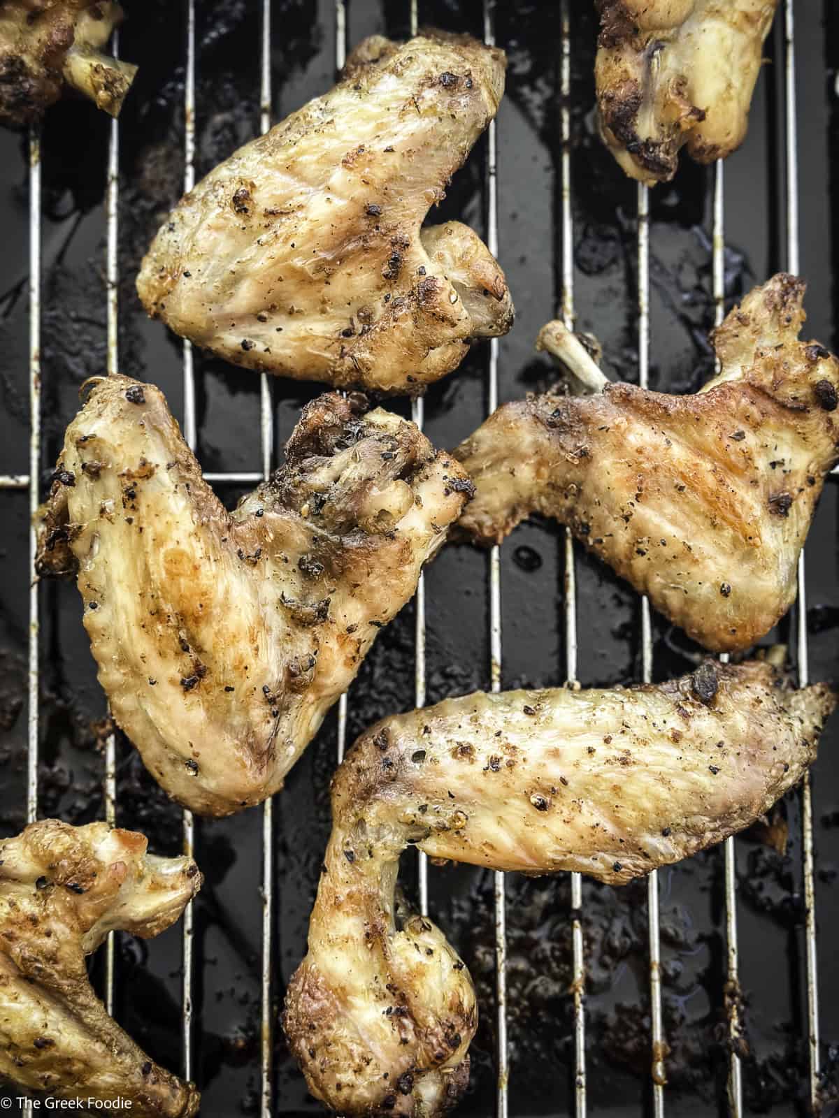 Cooked lemon pepper chicken wings on a wired rack.