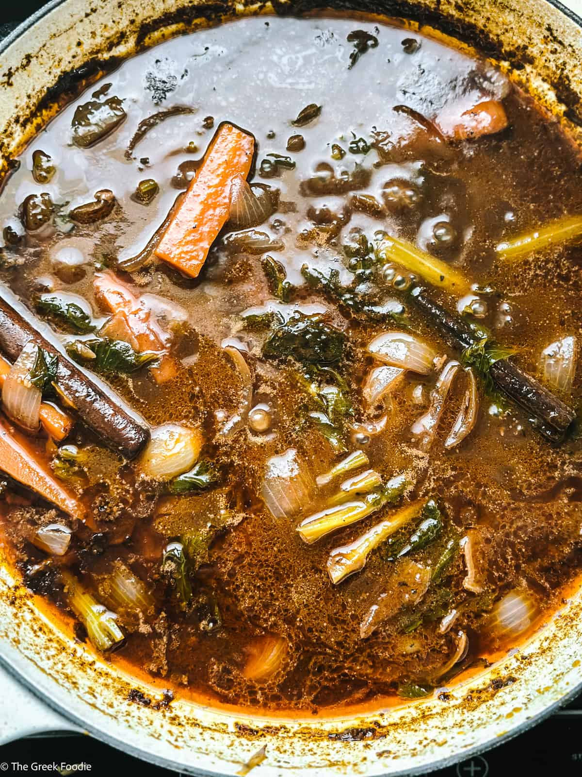 Wine sauce with carrots, celery and onions in a pot.