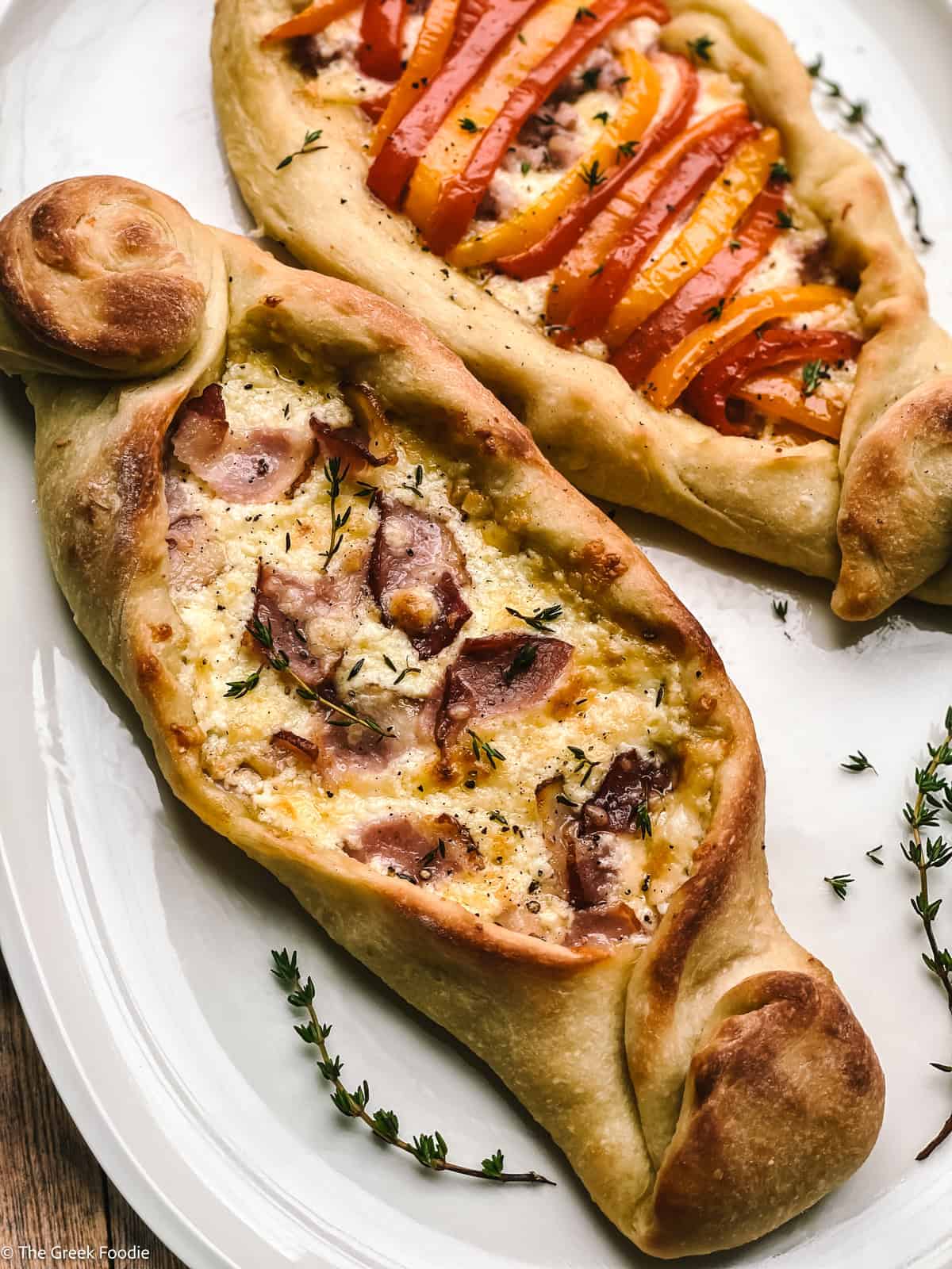 Two peinirli, Greek pizza boats on a platter.