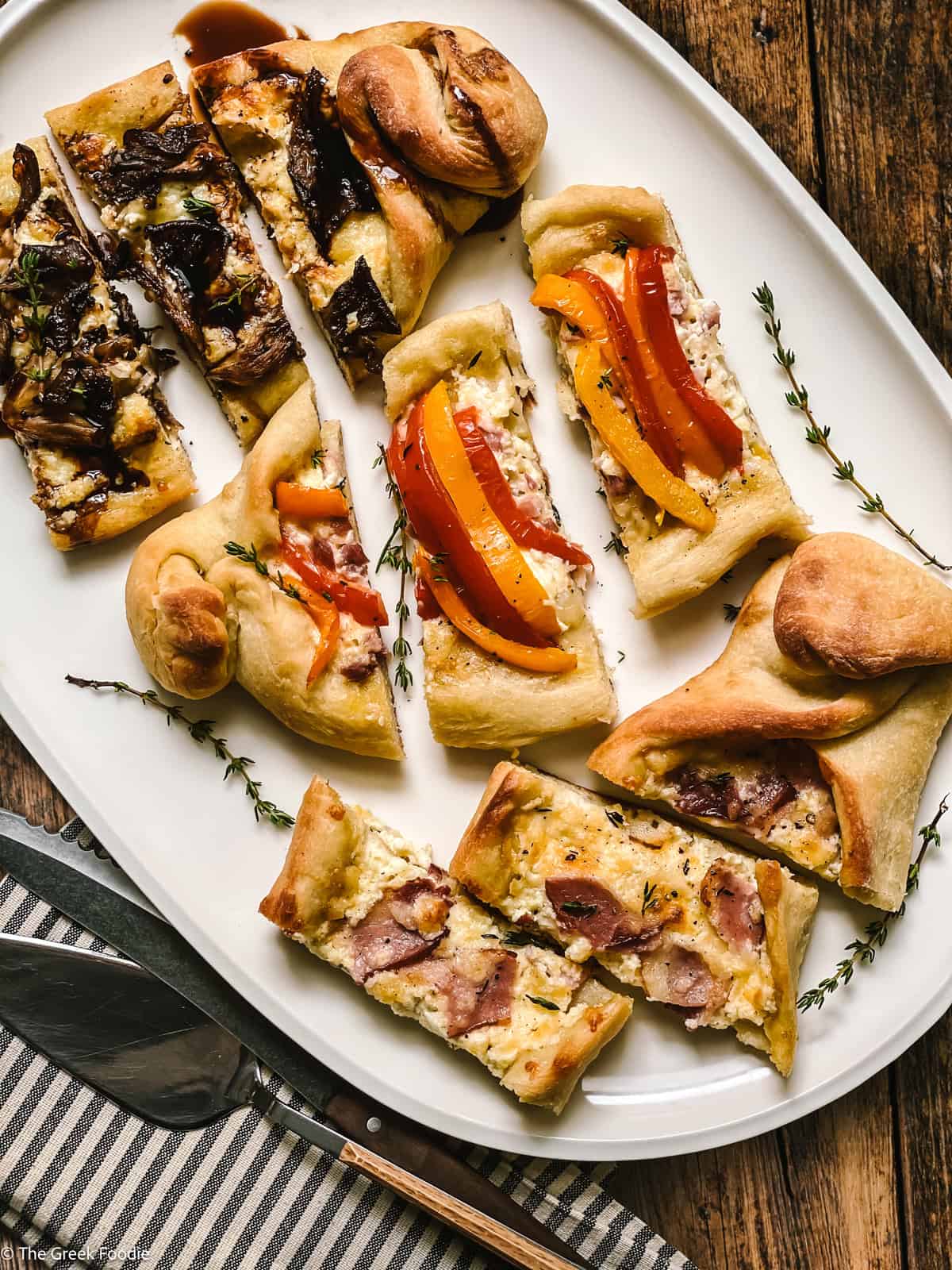 Three peinirli cut in pieces on a platter, on a table.