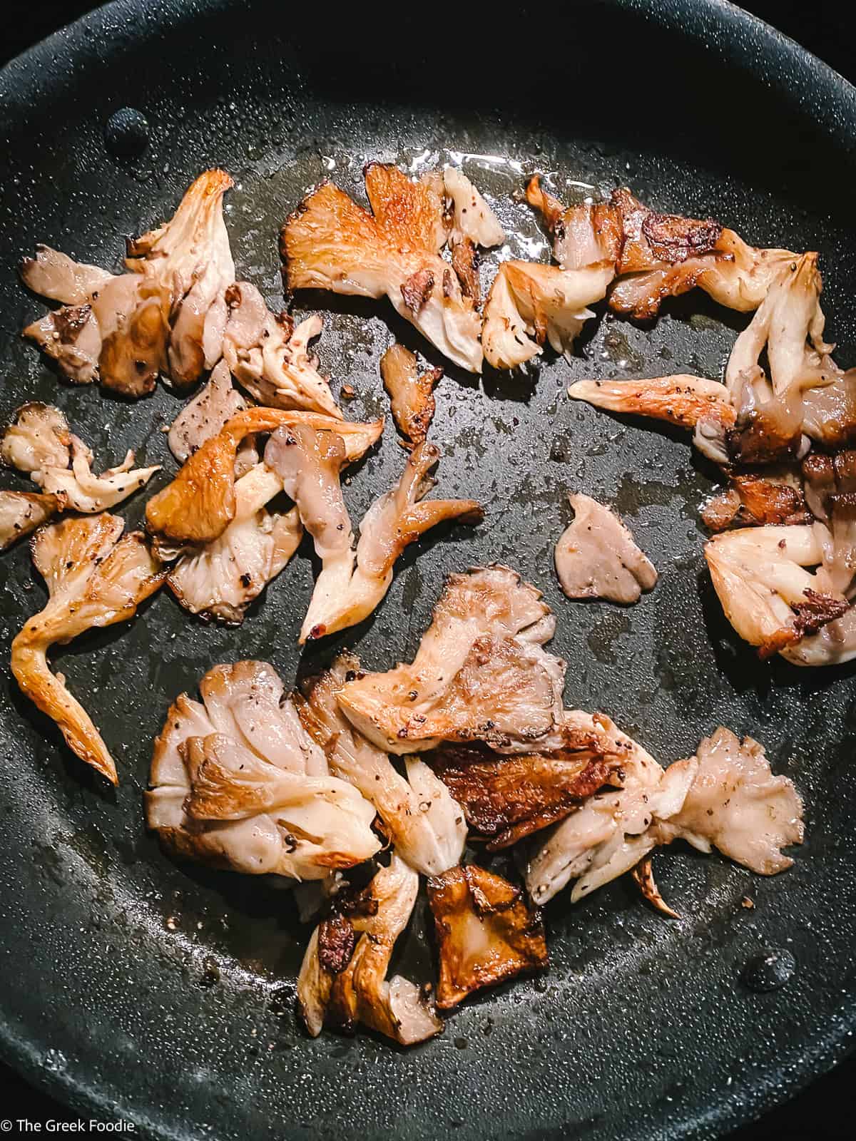 Oyster mushrooms frying in olive oil.