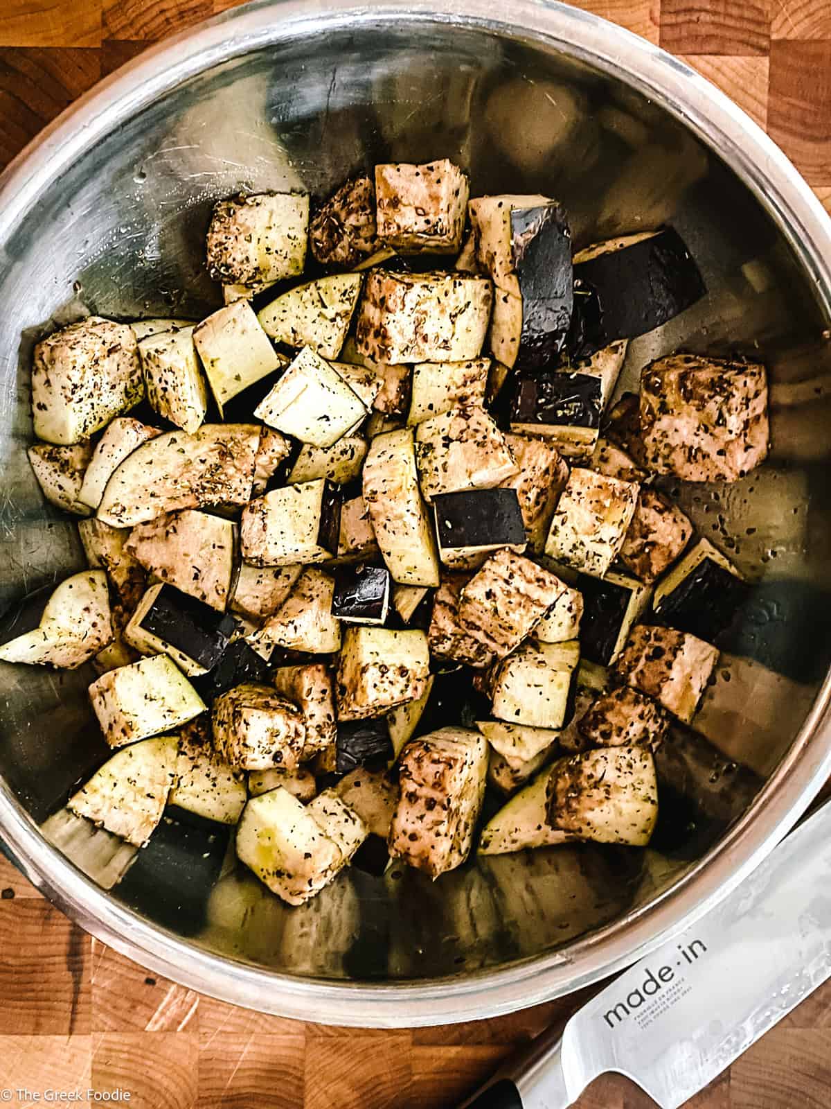 A bowl with eggplant cubes with seasonings.