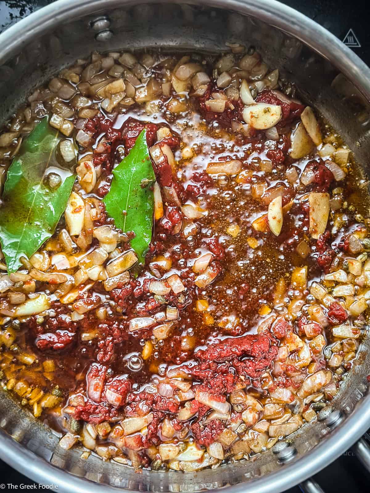 Chopped onions, seasonings, and two bay leaves.