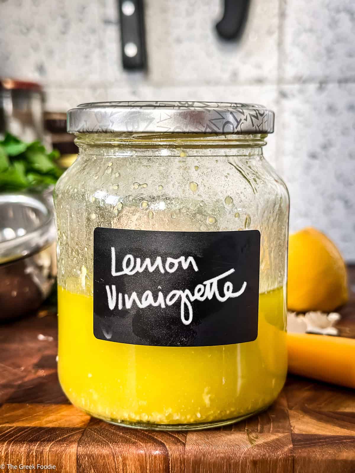 A jar with lemon vinaigrette in a kitchen.