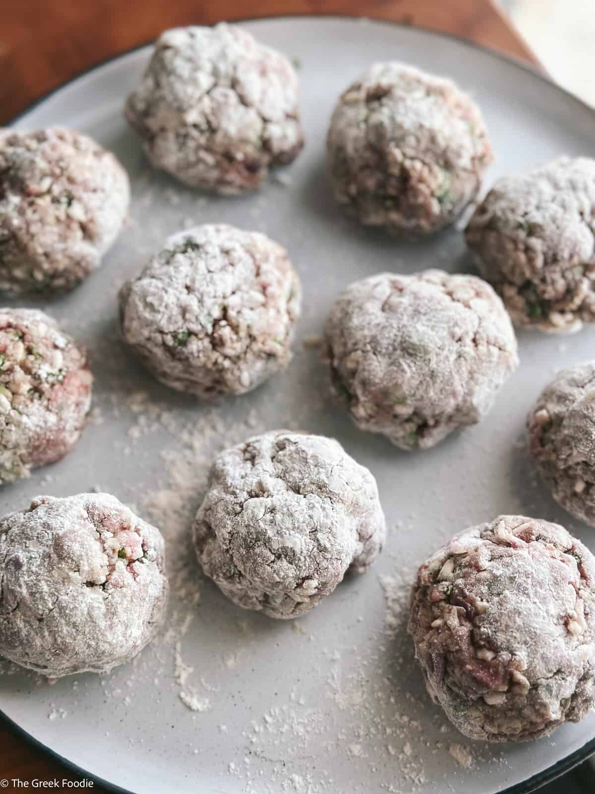 Youvarlakia meatballs with flour on a plate.