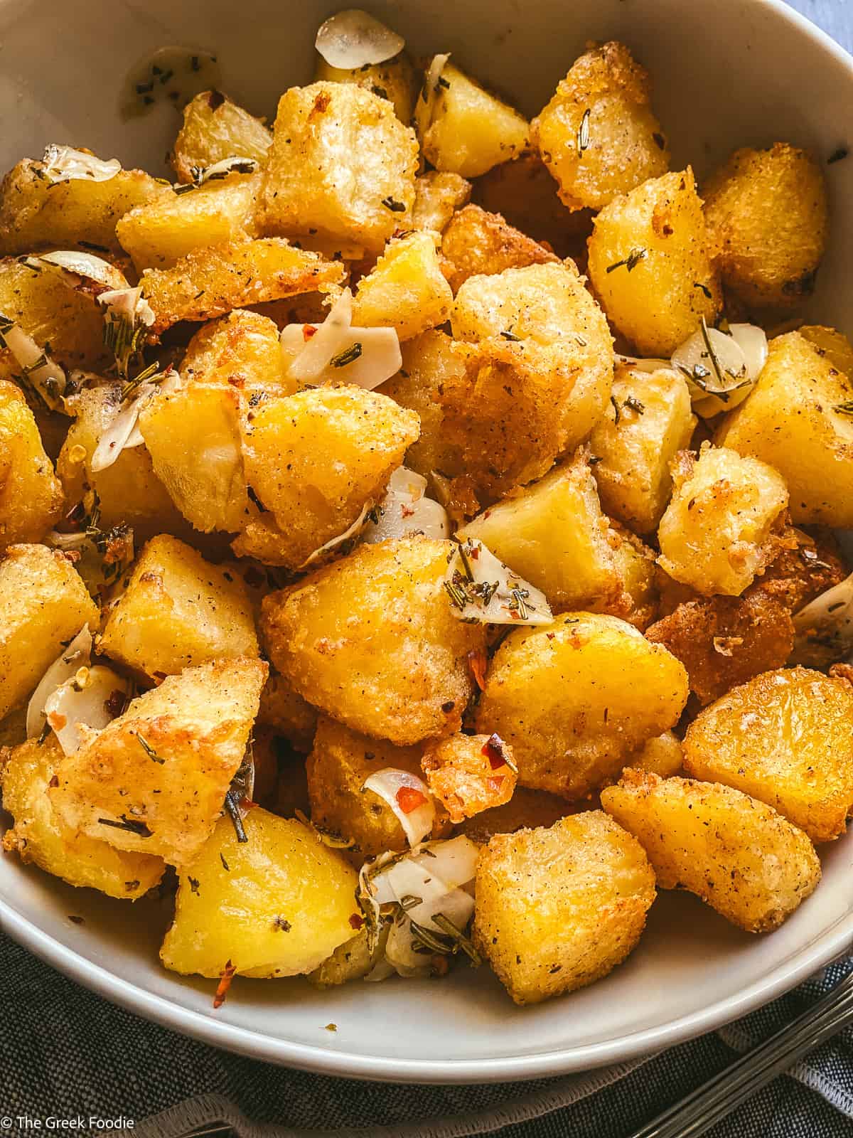 Crispy roasted potatoes potatoes with parmesan in a bowl.