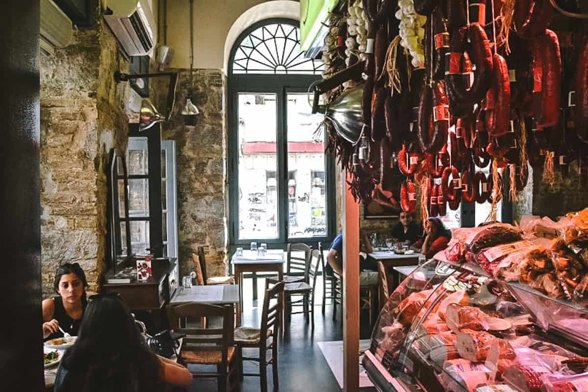 The interior of a traditional charcuterie shop with people dining.