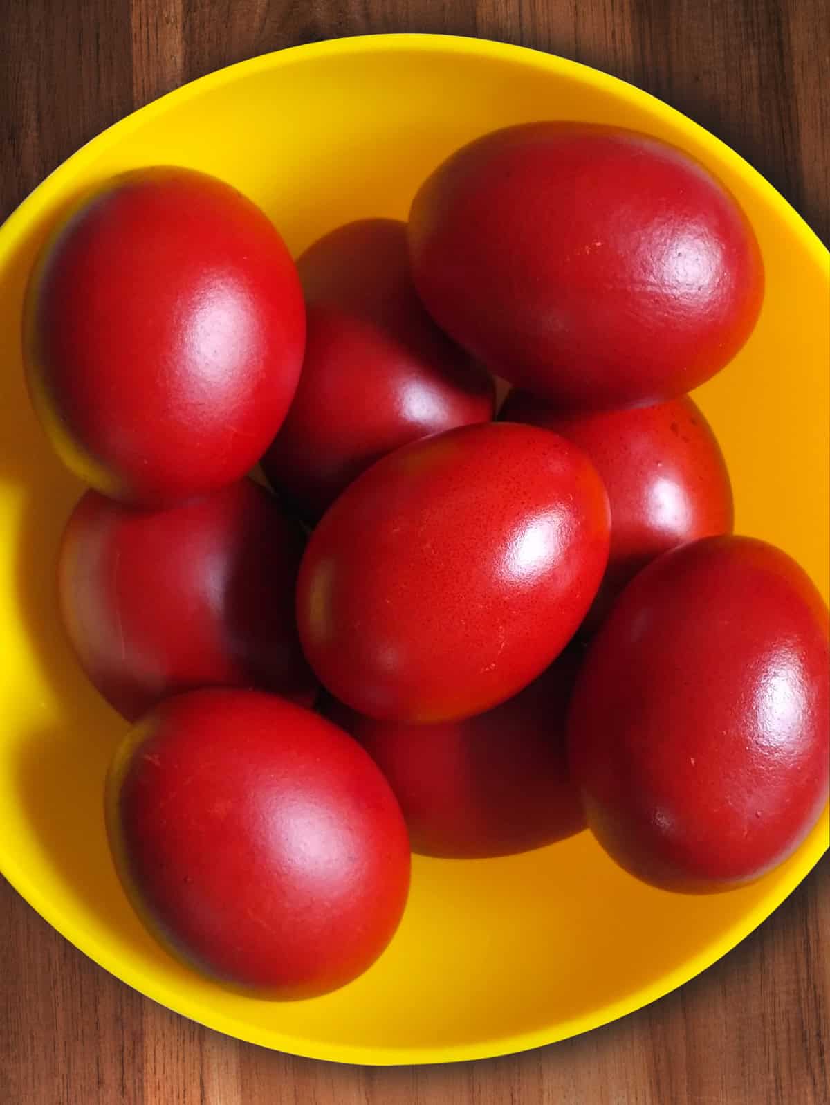 Red Easter eggs in a yellow bowl.