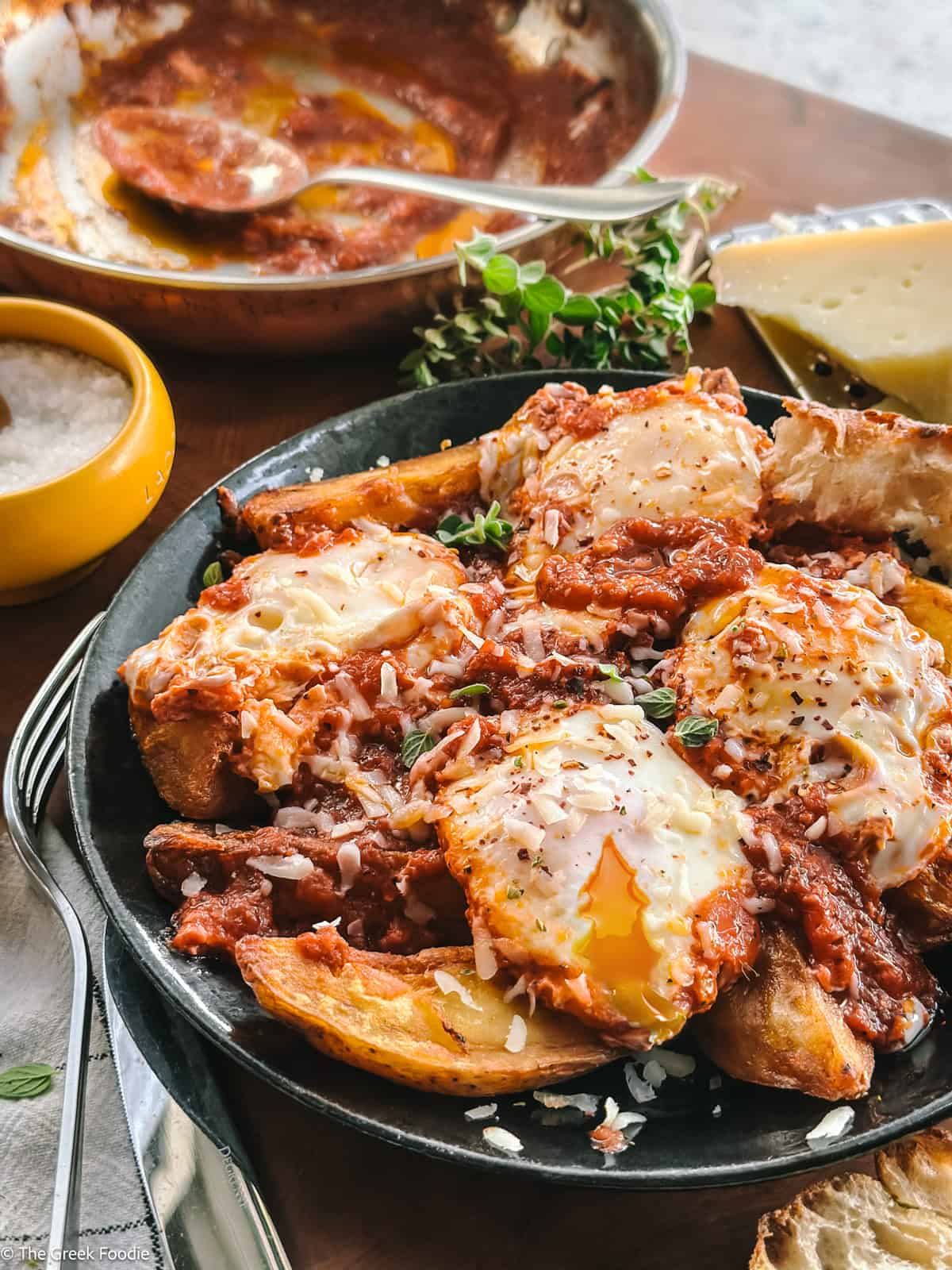 Greek eggs simmered in tomato sauce served over crispy potato wedges and finished with graviera, oregano, and chili flakes.