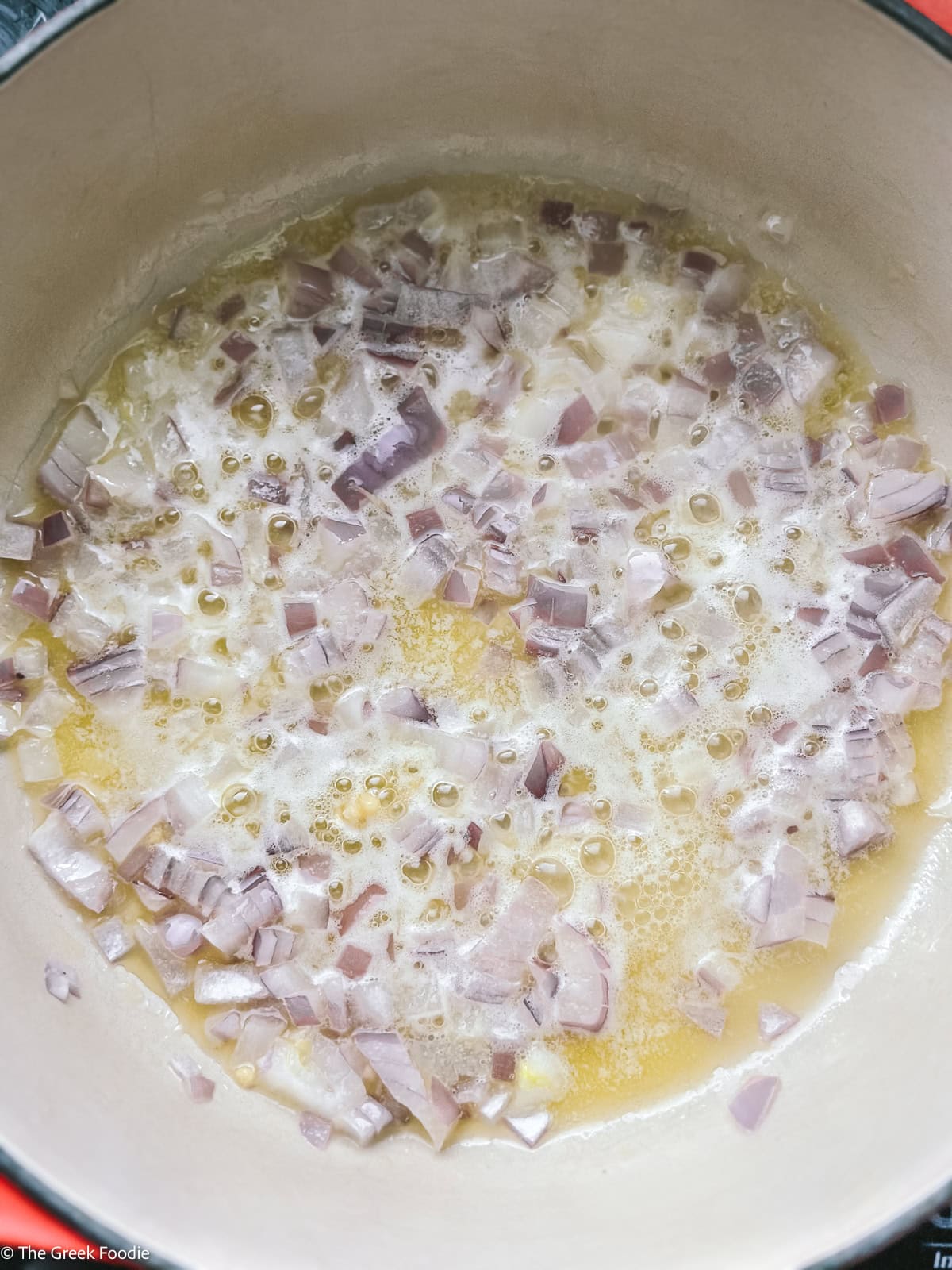 Finely chopped onion sautéing gently in butter as the base for Greek trahanas soup.