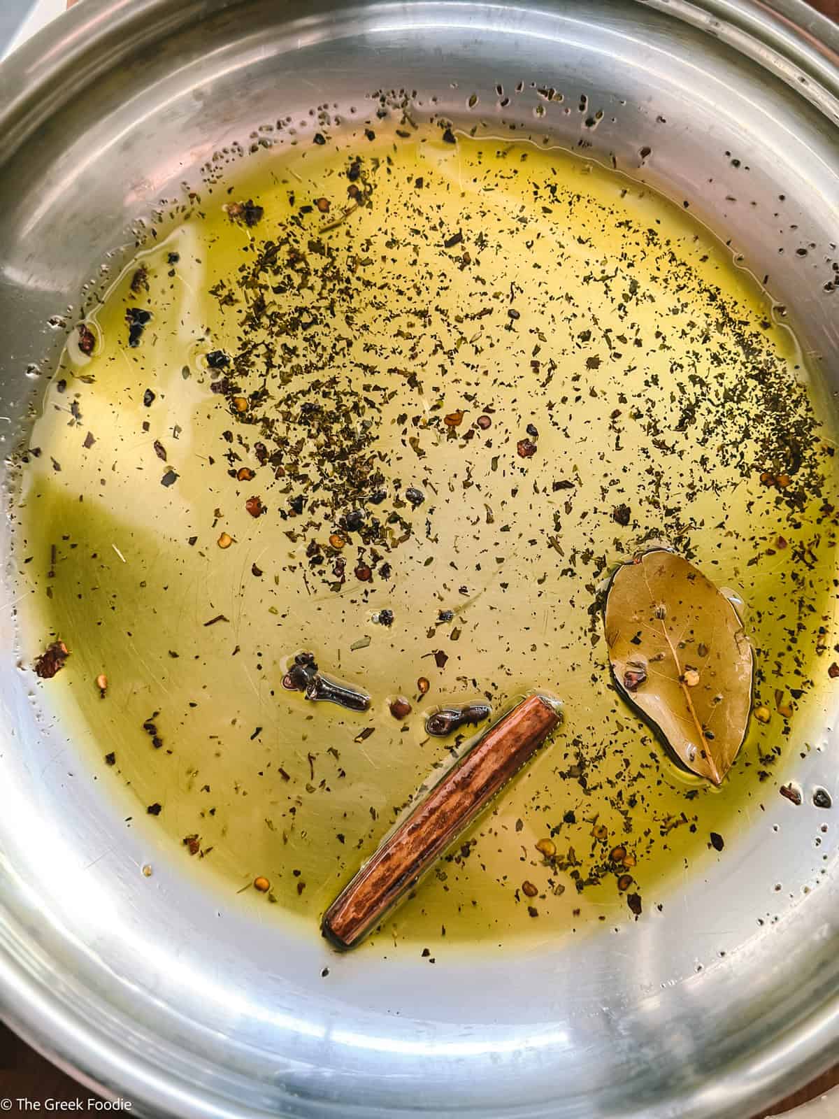 Olive oil gently infused with chili flakes, oregano, cloves, bay leaf, and a cinnamon stick before adding tomatoes.