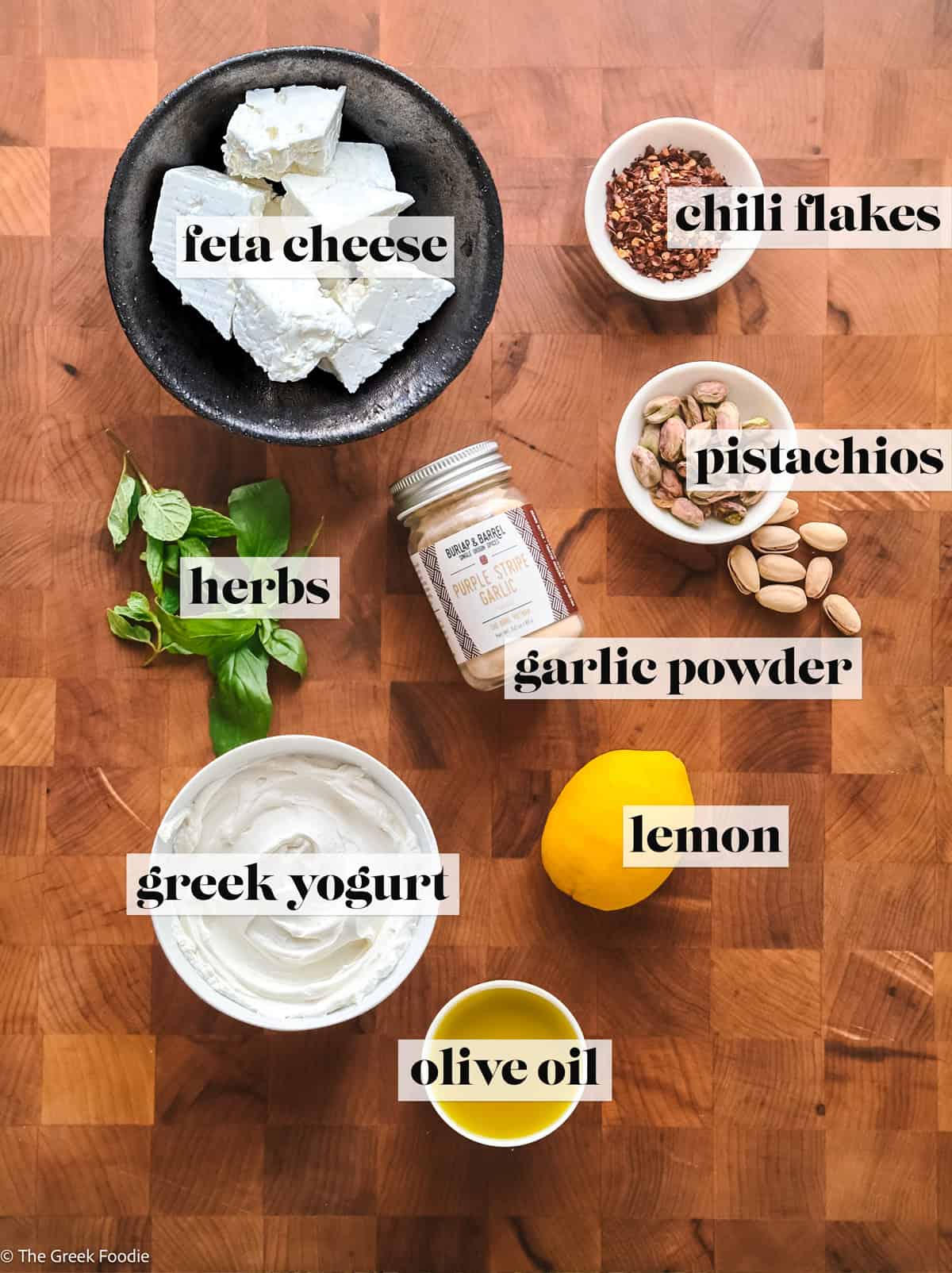 Feta, yogurt, herbs, olive oil, and lemon for making yogurt feta dip.