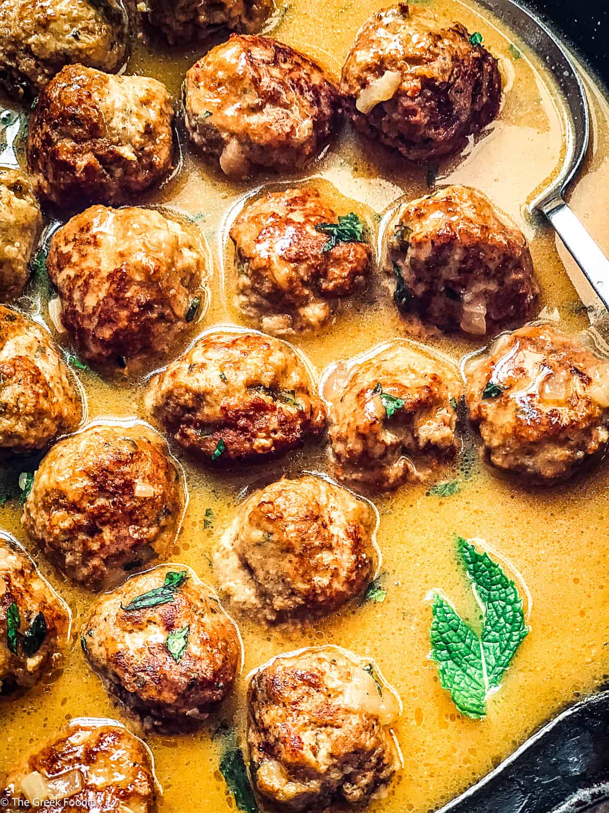 Low carb turkey meatballs and gravy with a spoon.