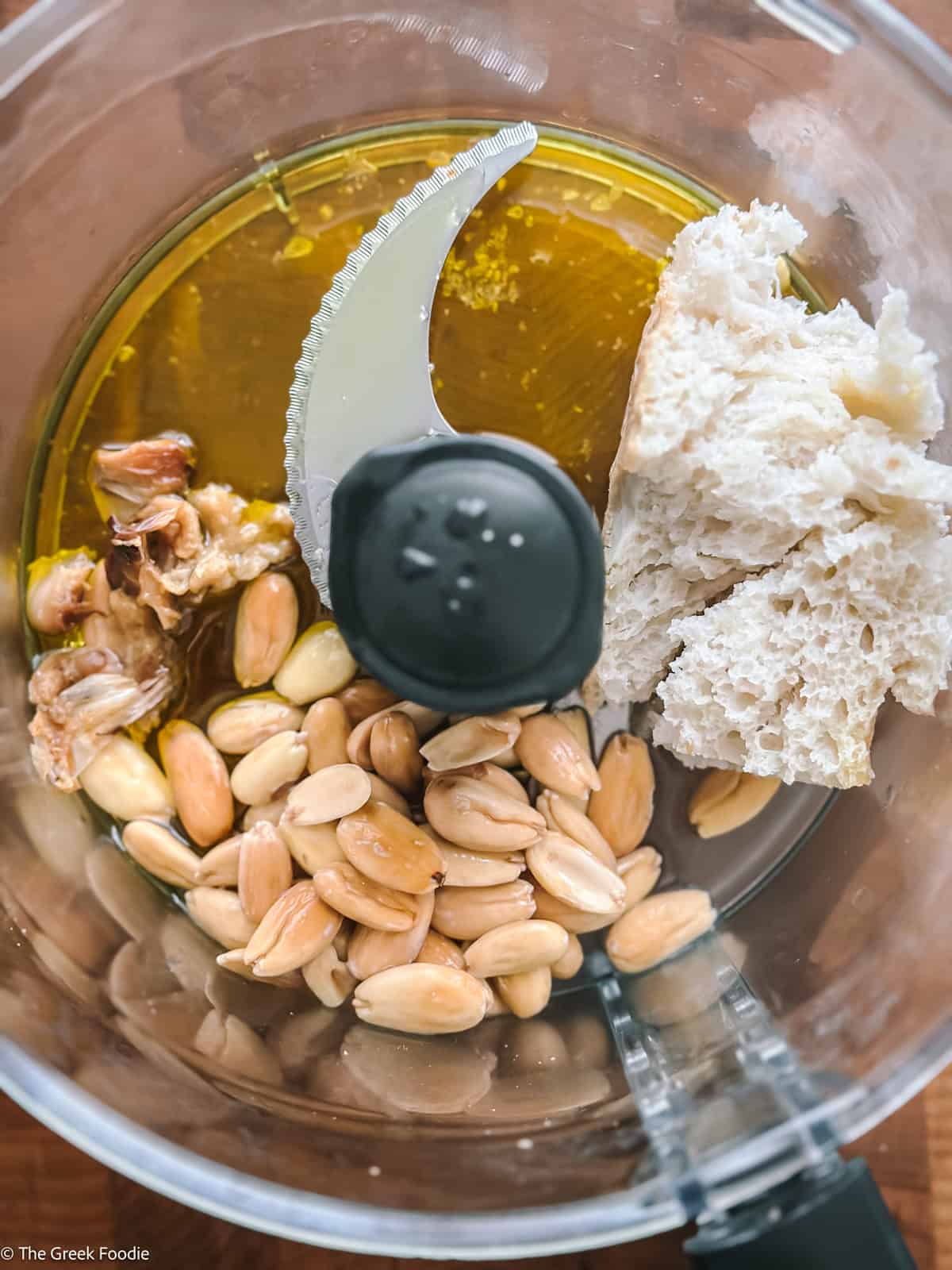 Blanched almonds and soaked bread in a food processor, ready to blend into almond skordalia.